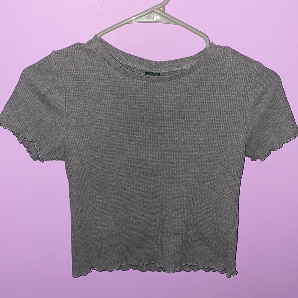 Small, grey petite shirt with ruffled sleeves and a ruffled bottom.